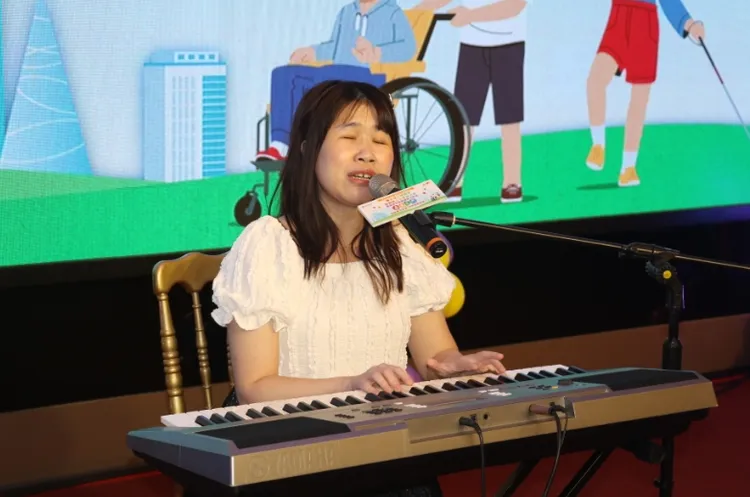 視障街頭藝人楊玉凡自彈自唱「人要自己走 鼓勵在場身障者。翻攝畫面