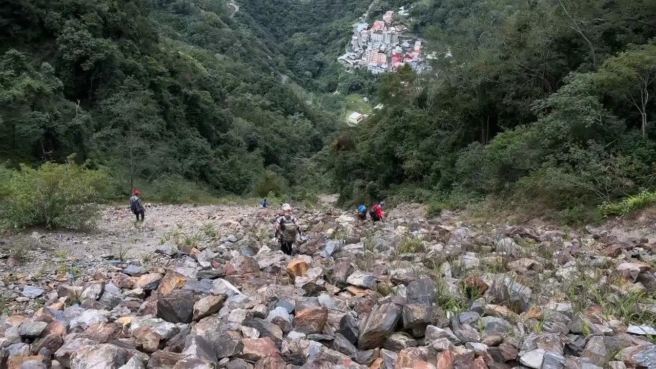 搜救人员在满是石砾的山坡搜寻失踪者。民众提供