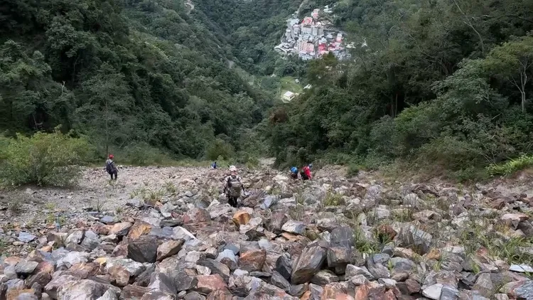 搜救人員在滿是石礫的山坡搜尋失蹤者。民眾提供