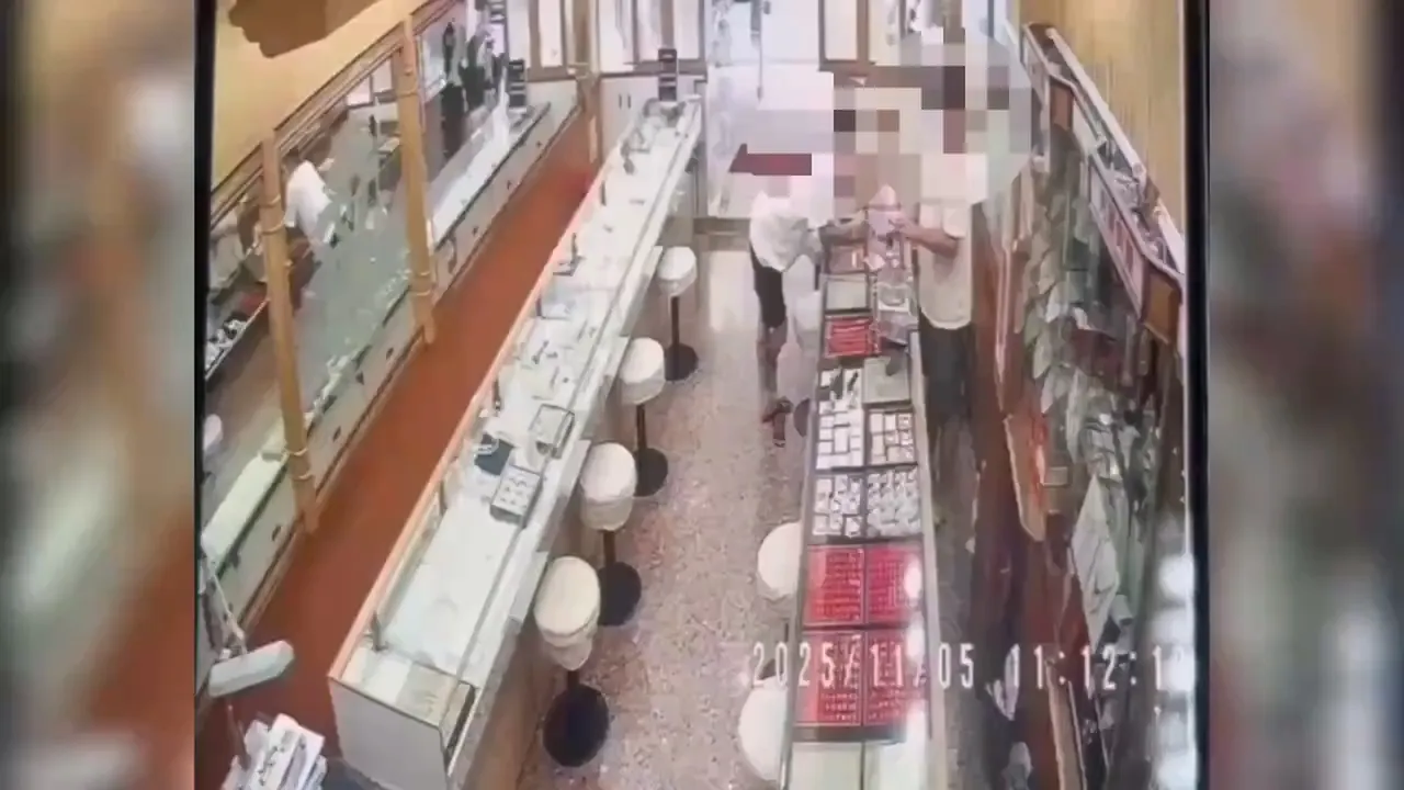 江嫌假借变卖戒指分散店主注意力，趁机窃取贵重金饰。翻摄画面