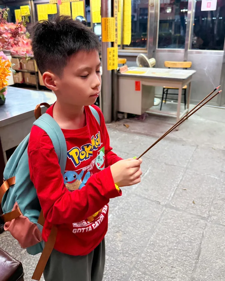 楊元慶帶著兒子楊硯到廟裡燒香拜拜，祈求找回包包，果然真的奇蹟發生了。翻攝自楊元慶臉書