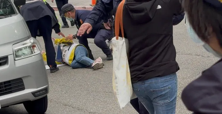 一名剴剴戰士疑似躺在路中央，意圖阻擋陳尚潔坐車離去。張欽攝