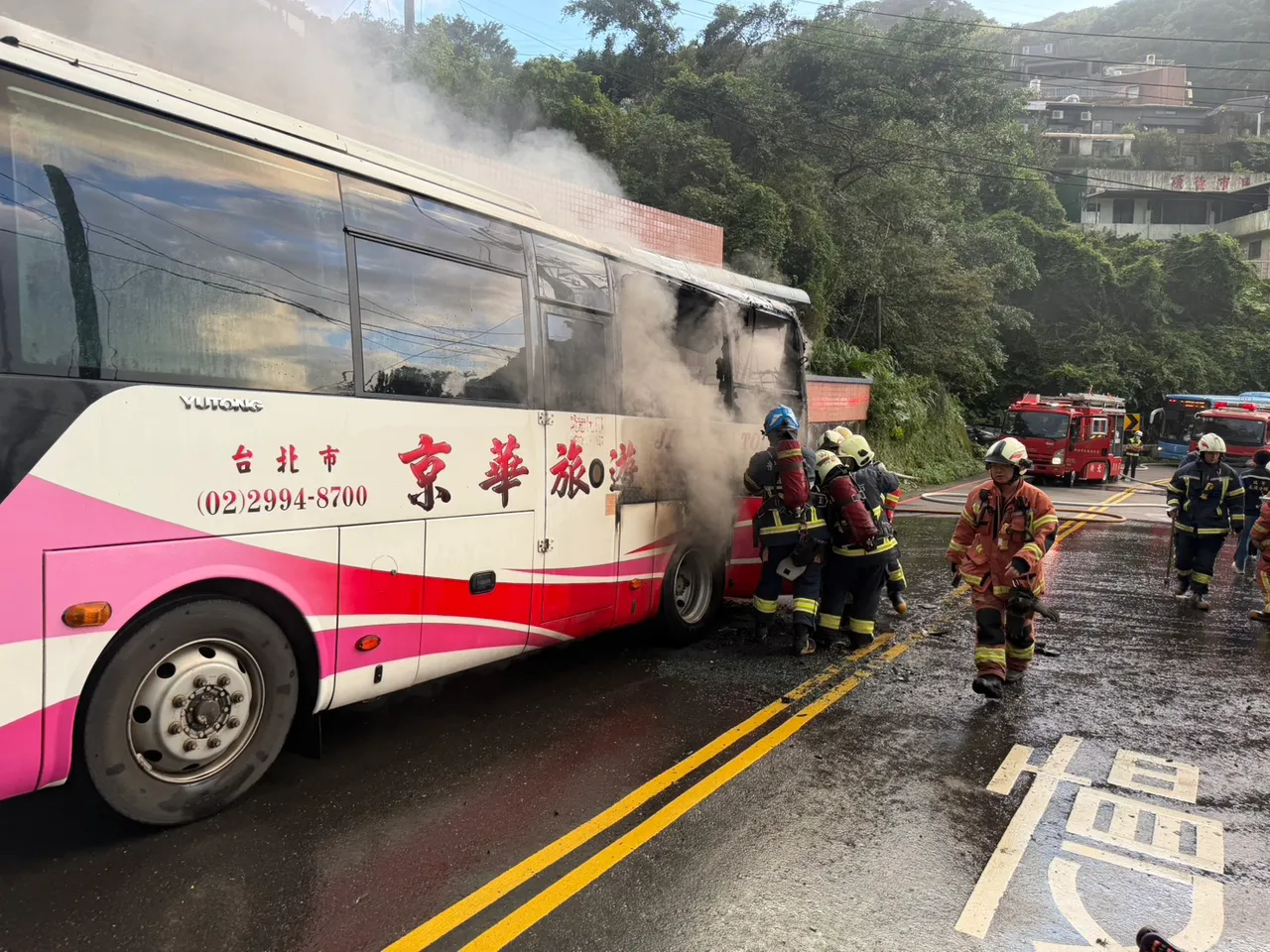 游览车火烧车被紧急扑灭，疑似起火源在车头，整个焦黑难辨。翻摄画面