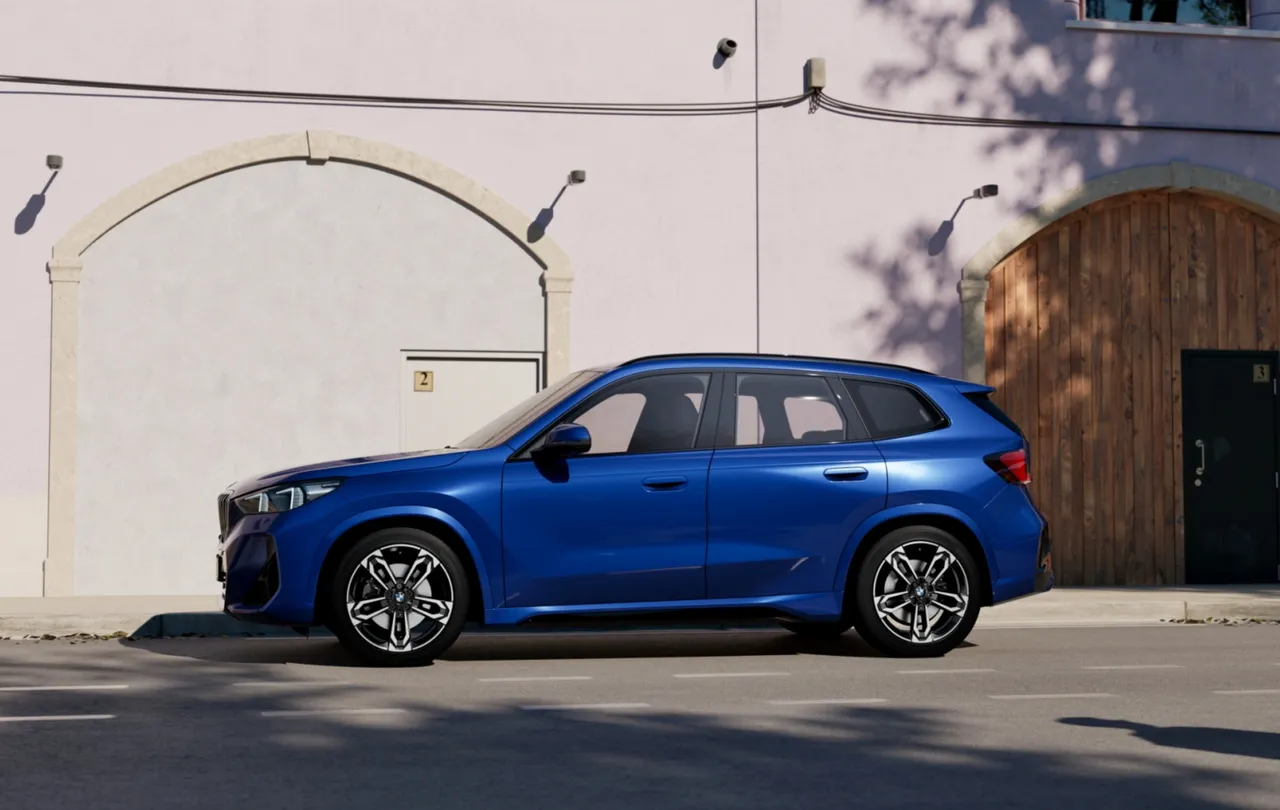 車側線條勾勒出鮮明肌理，搭配車身同色輪拱進一步降低視覺重心，結合M專屬輪圈、黑色高光澤窗框與車頂架，完美展現運動張力與俐落氣勢。原廠照片