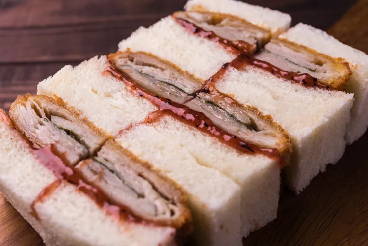 視覺效果滿分的「紫蘇千層豚里肌三明治」是選用肉質細緻的豬里肌，將醃製入味的肉片與紫蘇葉層層堆疊，炸至金黃酥香後，再夾入抹有日式梅肉醬與有鹽奶油的吐司中，打造鹹香酸爽的日式風味，每份售價580元。台北晶華提供