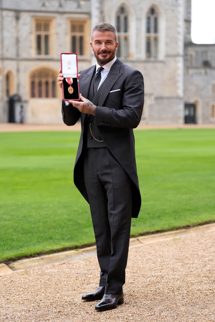 貝克漢穿著愛妻設計的訂製男士禮服封爵，表情流露感動與驕傲。美聯社