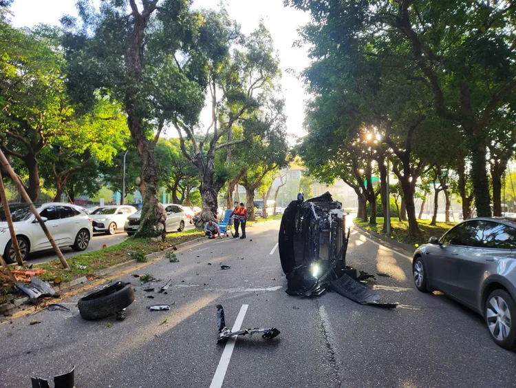 黑色小客车自撞后翻覆。翻摄画面