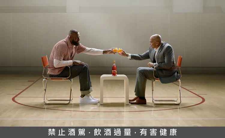 LeBron James标志性的「加冕」手势化为瓶身设计主轴，亮橙色象征荣耀与热情，体现品牌与文化能量的融合。业者提供