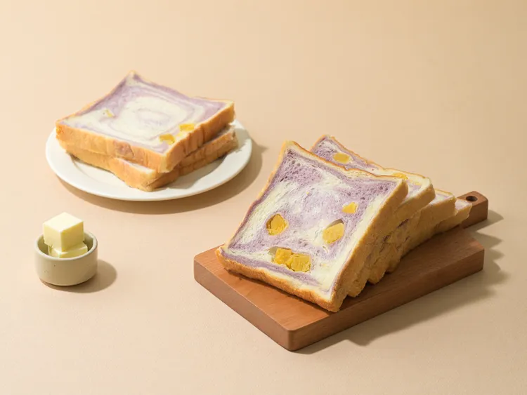 「紫芋地瓜吐司」（85元）鮮奶吐司麵團，加入了30%的喬伊鮮奶和19號純生鮮奶油等，雙色麵團帶些牛奶芋頭香，地瓜丁塊綿細化口，風味口感讓人著迷。19號發酵奶油提供