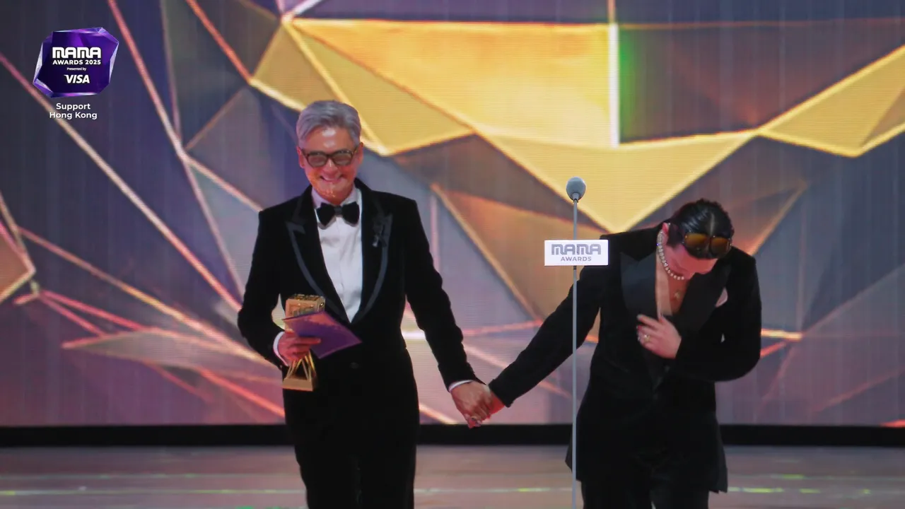 GD（右）上台領年度藝人獎，被周潤發牽手熱舞，害羞直笑。翻攝Mnet