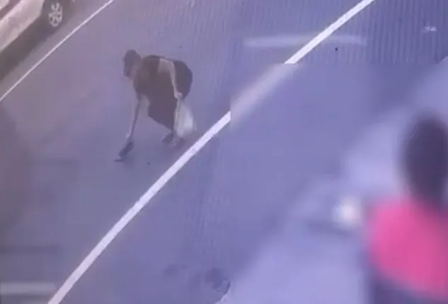 路過民眾彎腰拾起錢包。翻攝畫面