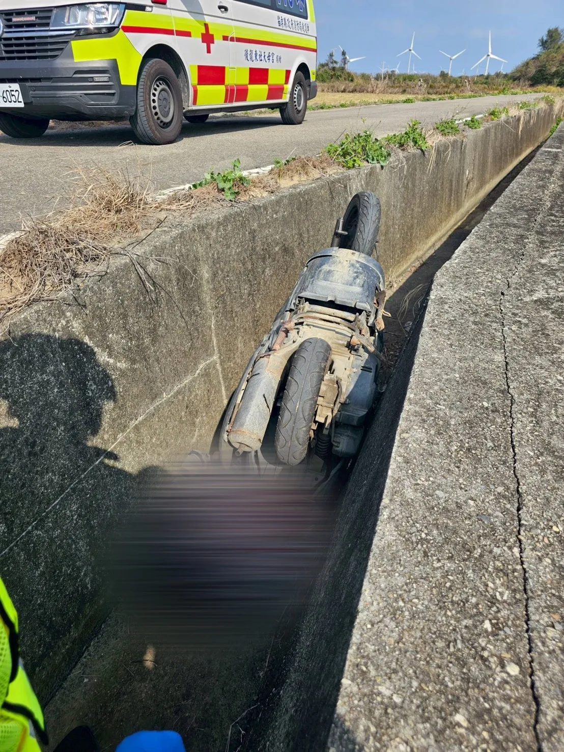 张翁连同机车摔入排水沟，机车2轮朝天。民众提供