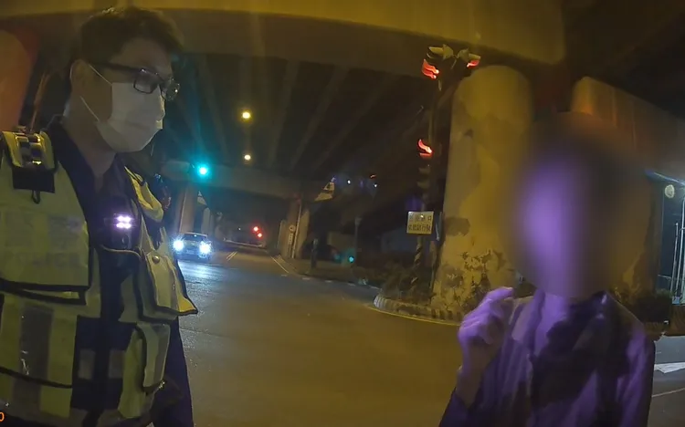 有失智情形的張婦深夜走在車道上，警方趕緊上前將她帶離並通知家屬帶回。翻攝畫面