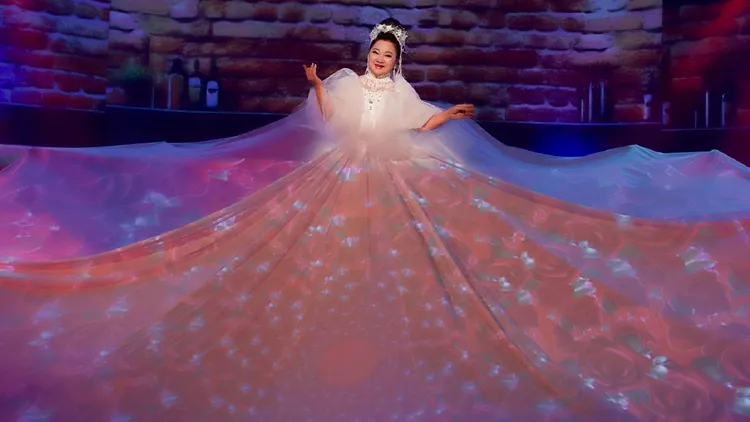 节目团队使用电脑灯，打上千变万化的图案于白冰冰长裙上，整体气势有如拉斯维加斯大秀。民视提供