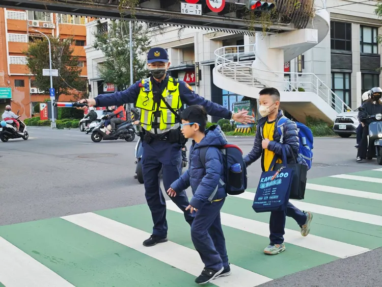 台中市警一分局員警在忠孝國小執行護童勤務，引導學童過馬路。民眾提供