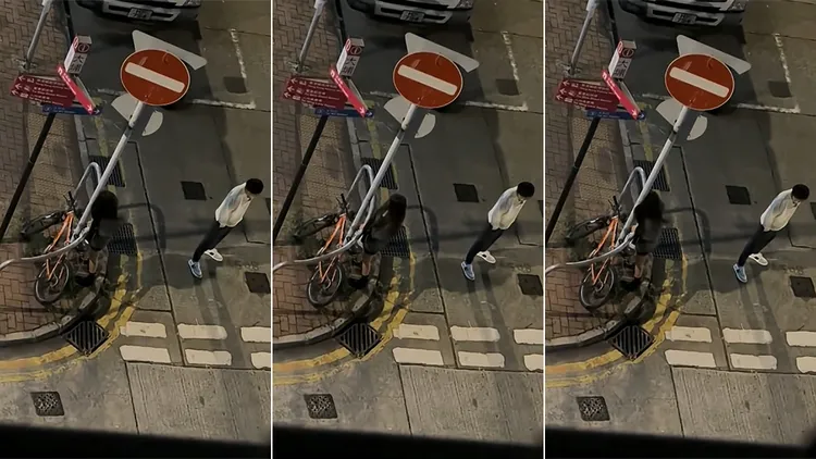 情侣深夜在马路上发生争执，女子当场用头去撞路旁交通标志铁柱。翻摄自YouTube