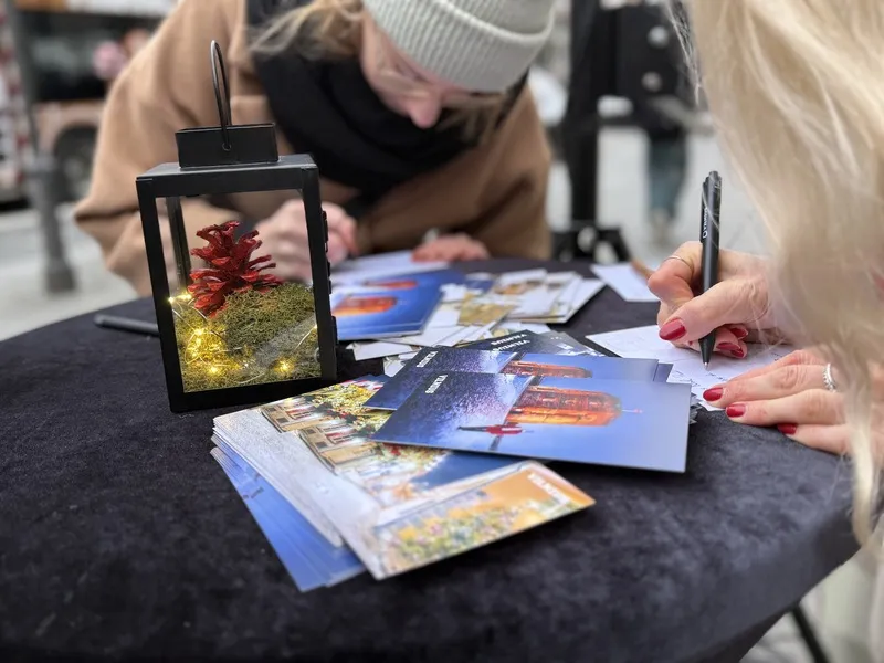 立陶宛首都维尔纽斯举办「耶诞节前的耶诞节」活动， 官方旅游推广单位Go Vilnius在市区多个地点放置耶诞明信片与邮筒，免费供民众寄送至海外，向亲友传递节日祝福。桌上的红色松果为「耶诞货币」。 中央社