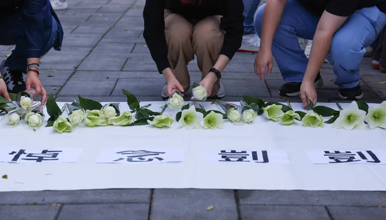 社工們在地上鋪有寫著「悼念剴剴」的白色桌巾，並擺放白百合哀悼。中央社