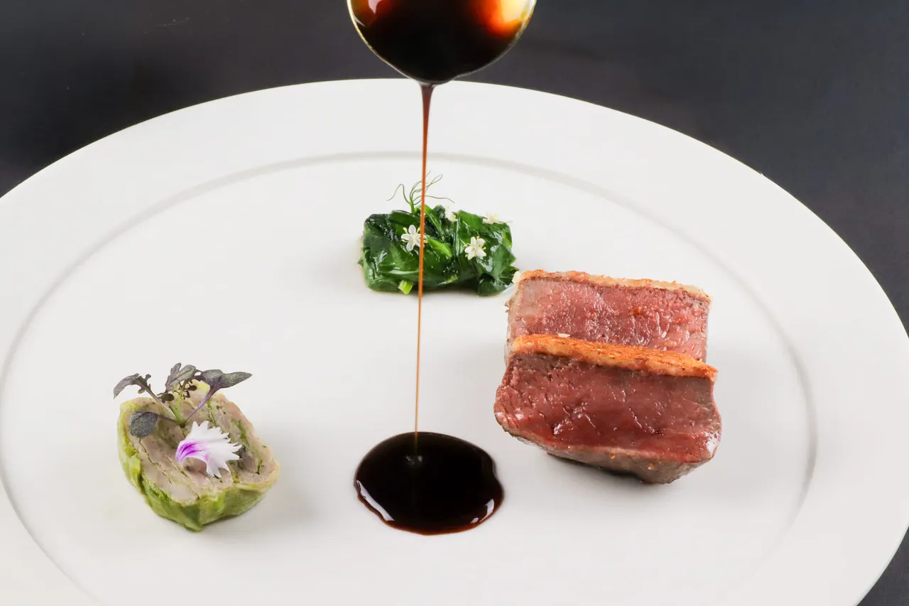 纽西兰鹿肉：选用纽约客部位，表面包覆杜松子香料酥壳，带有马告香气的酱汁，融合辛香与山林气息，呈现清朗的冬季野味风景。业者提供