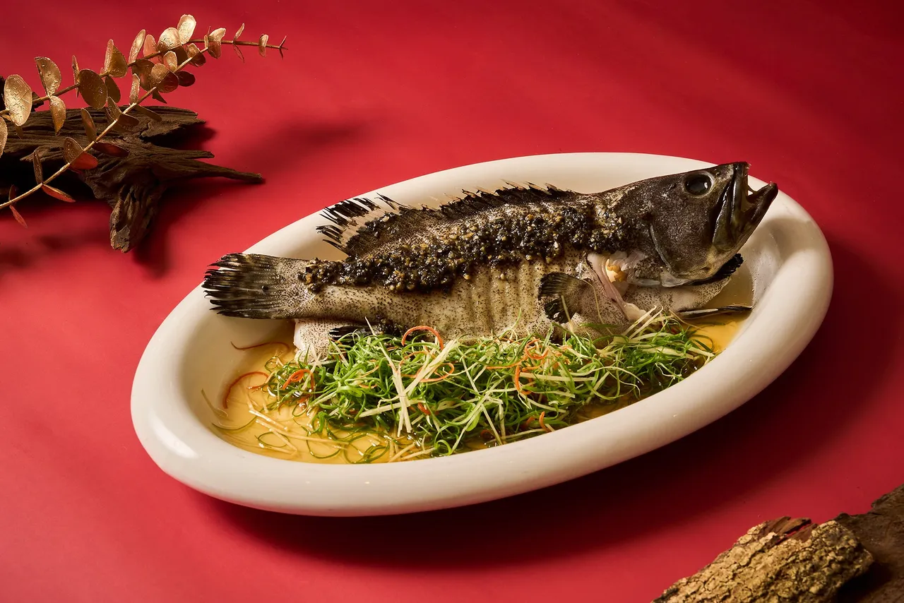 「黑金蒜酱龙虎斑」加入黑蒜、话梅与风干大地鱼提升蒜香层次，售价1880元。台北新板希尔顿酒店提供