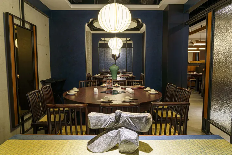 鼎王台北長安東店的空間設計，以「古典雅緻」為底蘊，精心揉合溫潤木質紋理，妝點穩重藍紅色系，以藝品點綴每個角落。業者提供