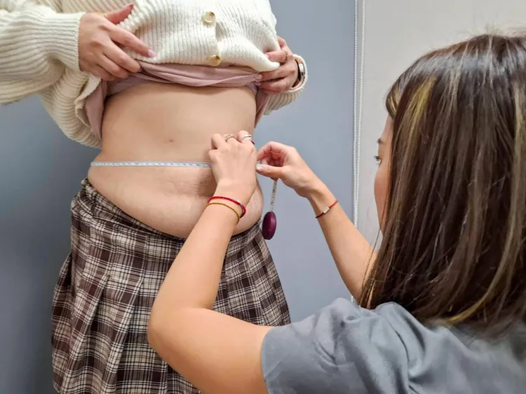 減脂教練正在為客人測量腰圍。