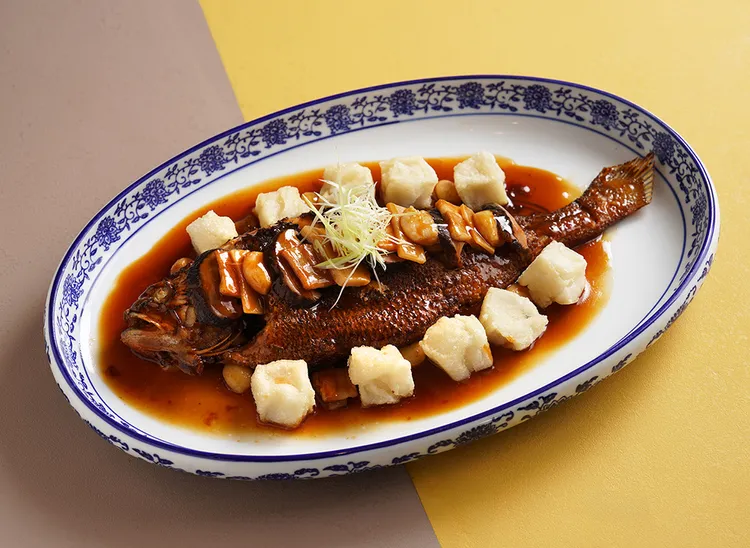 「滬式年糕燒黃魚」以鮮活黃魚搭配自製糯米年糕㸆燒，展現江南濃油赤醬風味。台南遠東香格里拉提供