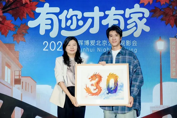 王力宏（右）从基金会创办人邢戎女士接到孩子们绘制的30周年画作，忍不住哽咽。西东音乐提供