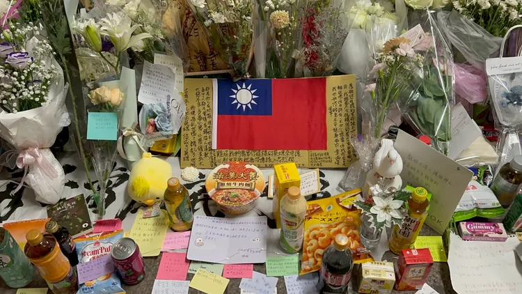 民眾在台北車站擺放鮮花、國旗與卡片悼念余家昶，現場堆滿供品與手寫字條。攝影中心