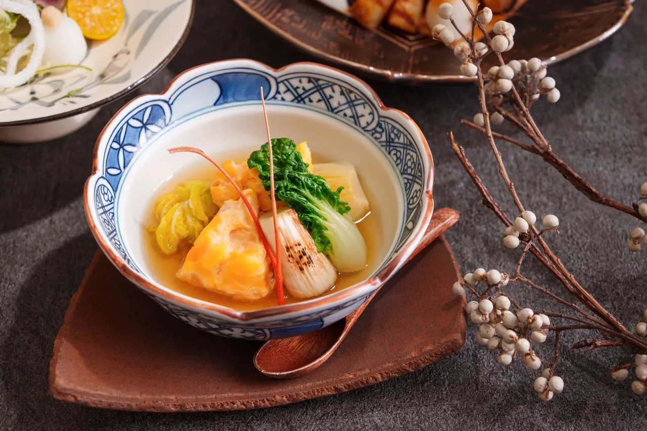 台北喜来登桃山冬季会席菜色「龙虾黄味煮佐旨味高汤」，以蛋黄液拌入虾膏包覆鲜活龙虾，经高汤细火缓煨，肉质柔润细致。台北喜来登大饭店提供