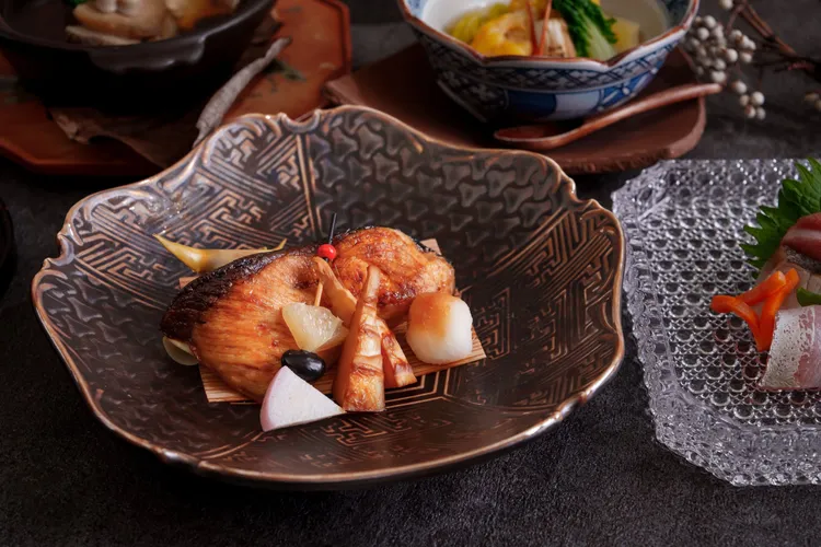 台北喜來登桃山冬季會席菜色「炙燒鱈魚白子佐蓮藕泥庵」，細緻炙燒使白子釋放柔滑奶香與鮮甜，搭配如雪花般的蓮藕泥，平衡油脂厚度，溫潤中透出清爽層次。台北喜來登大飯店提供