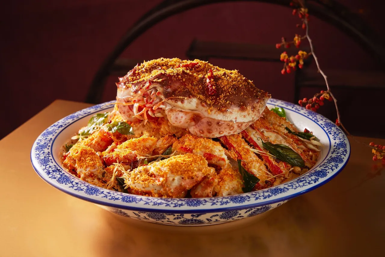 严选活体帝王蟹，于粤式避风塘炒法中融入川味辛香，再与蒜酥炒成底料，加入裹上脆浆的蟹身拌炒，蟹壳薄脆金黄、蟹肉鲜嫩喷汁，蒜香浓郁、辣而不麻。台北喜来登提供