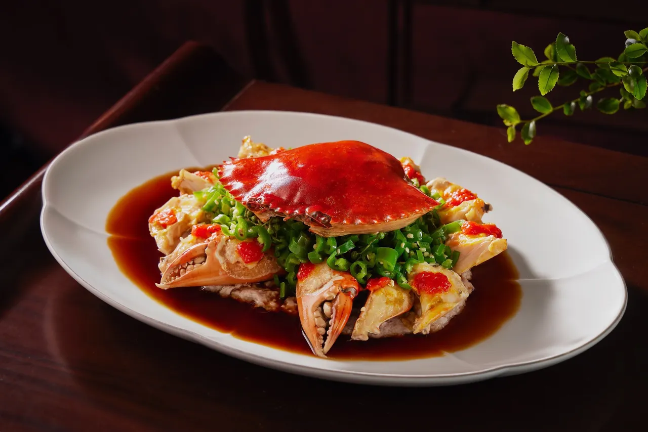 每日手拨新鲜蟹肉制成肉饼并铺上金黄蟹膏一同蒸制，出炉后摆上满满的青辣藤椒以及淋上特制鱼露椒汁，青花椒带柠檬香气，微麻轻辣激发蟹肉鲜味层次。台北喜来登提供