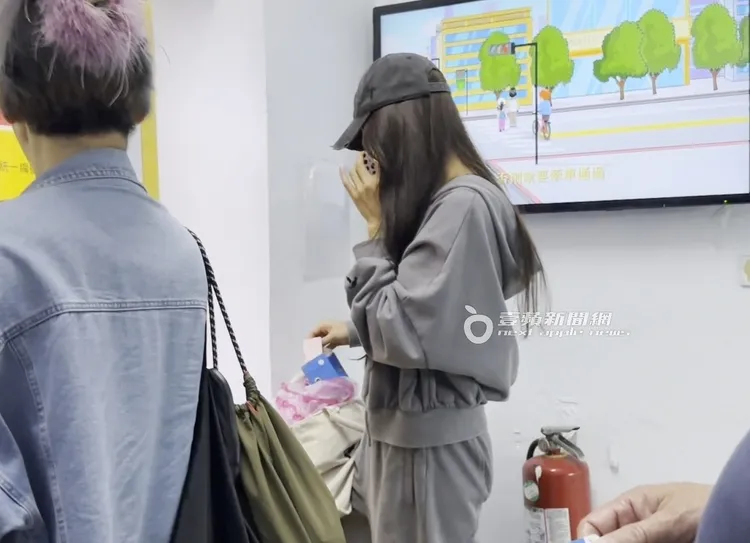 吳速玲邊講手機，掏出皮夾準備付停車費。特勤中心攝