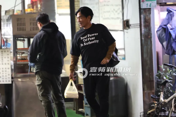 吳宗憲提著一大袋外帶餐點向老闆娘道別後離開。特勤中心攝