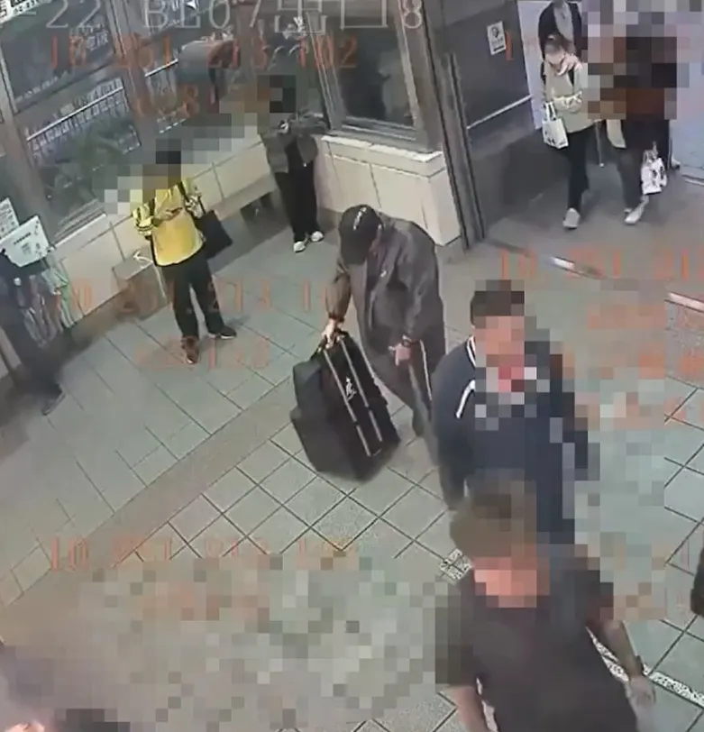 张文身穿连身雨衣进入北车。翻摄画面