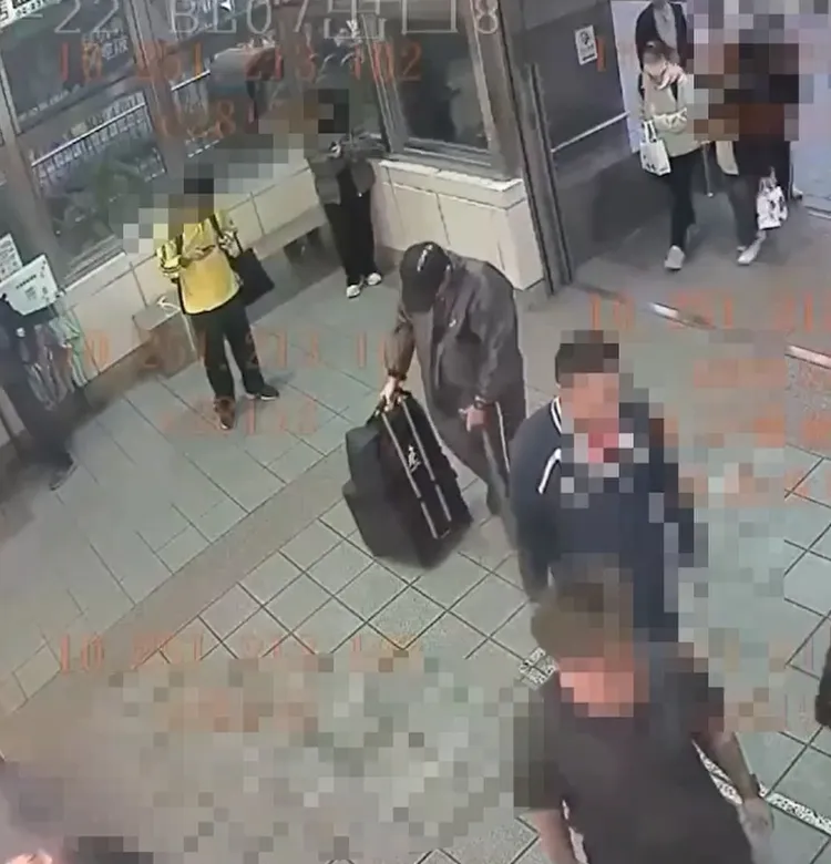 張文身穿連身雨衣進入北車。翻攝畫面