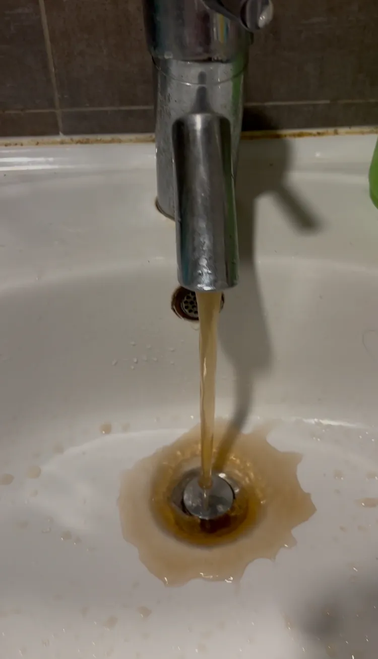 淡水區復水後，民眾家中水龍頭流出帶有泥沙的褐色水。邱筠媜攝