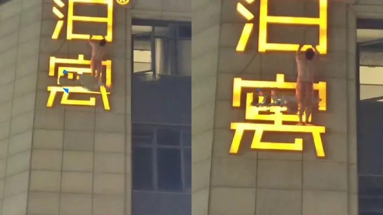 男子全身只穿內褲吊掛在外牆招牌上。翻攝自微博@七七耶耶耶耶