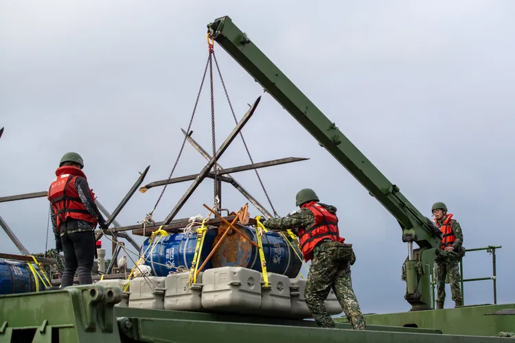 工兵部隊透過浮門橋車放置阻絕油桶。國防部提供