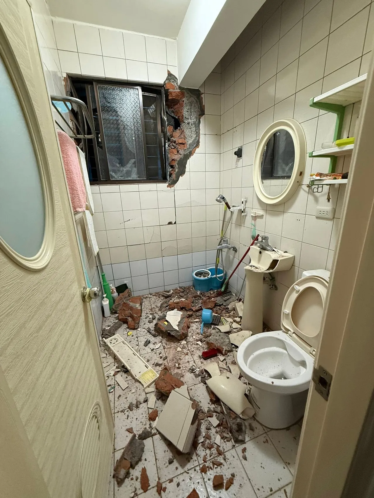 混凝土块溢流进民房外墙，造成内部洗手台破损，多处泥堆土块。翻摄自黄心华脸书