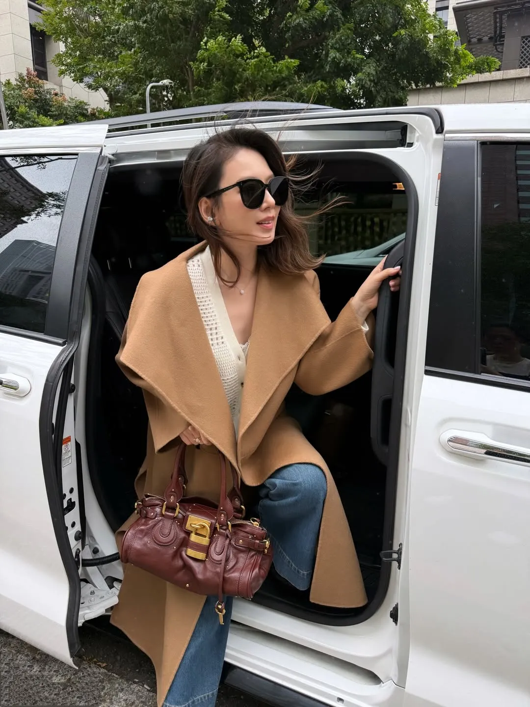 Melody以棕色长大衣、牛仔裤搭配红棕色锁头包，打造出优雅休闲风格。翻摄Melody IG