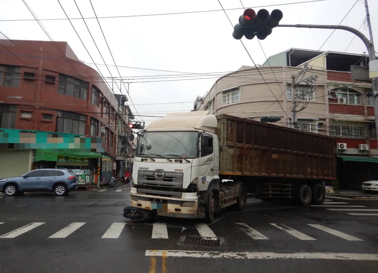曳引车迳自左转，造成对向骑来的机车闪避不及打滑，连人带车卡进车底。民众提供