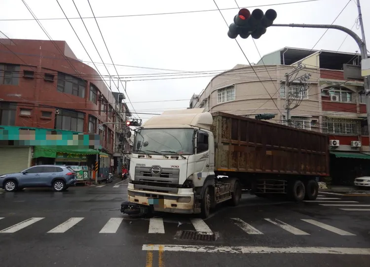曳引車逕自左轉，造成對向騎來的機車閃避不及打滑，連人帶車卡進車底。民眾提供