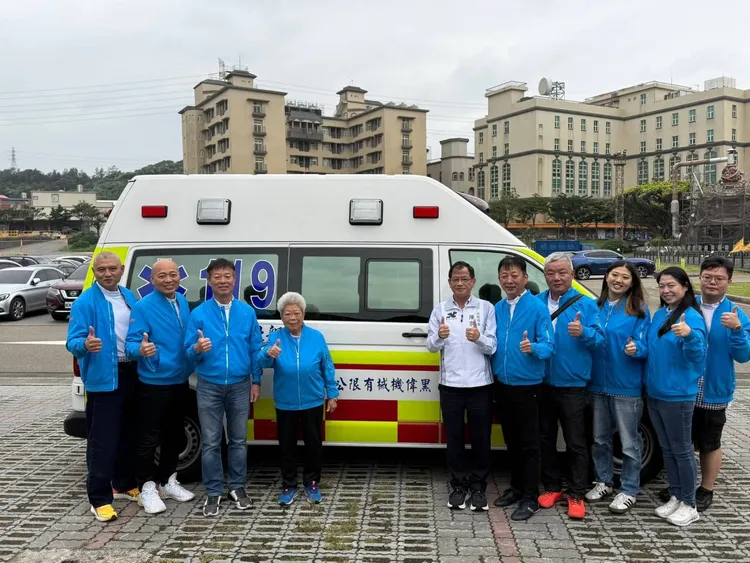 消防局長陳崇岳與捐贈者於高頂救護車前合影。翻攝畫面