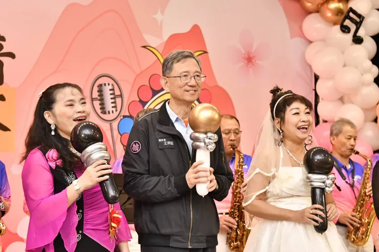 王明巨(中)为选手们加油打气。社会局提供