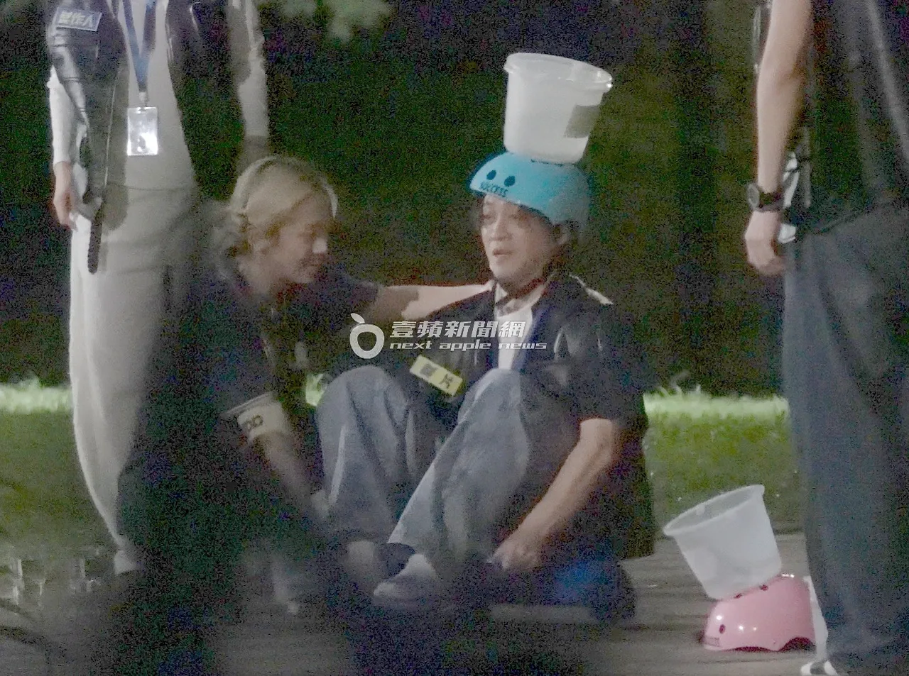 Lulu（左）抚摸陈汉典肩膀，陈汉典则一心注意著头上的水桶。特勤中心摄