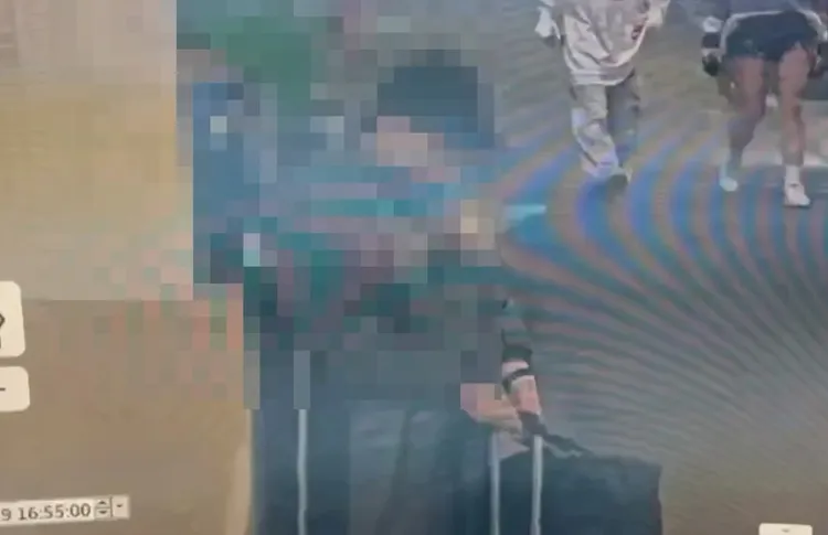 張文身穿連身雨衣進入捷運站，與旁人還有穿短褲的穿著有極大差異。翻攝畫面