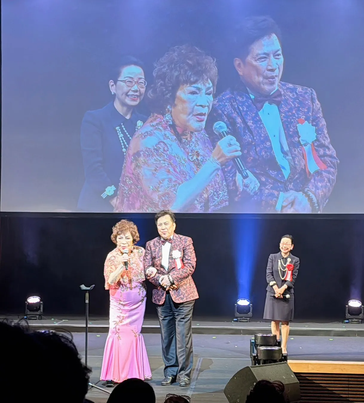 阿姑（左）与李朝永(右)赴日参加选美活动，上台致词。李朝永提供