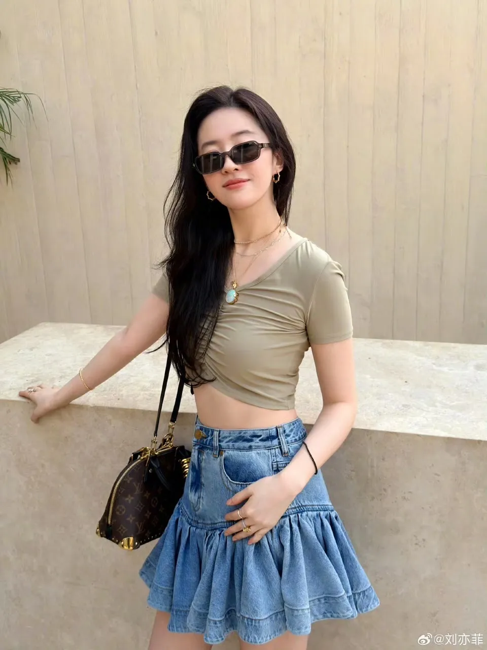 刘亦菲以短版上衣搭配牛仔短裙，自信晒出紧实小蛮腰。翻摄刘亦菲微博